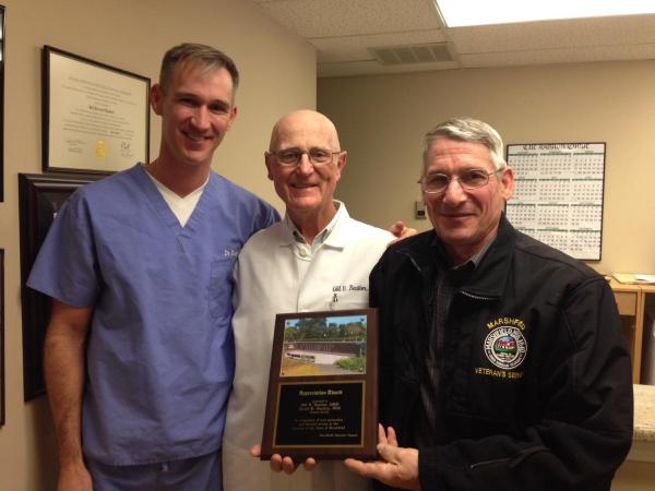 Veterans Service Officer Bill Dodge presents a plaque on behalf of the Marshfield Veterans Council to Bastien Dental for their continued support of local veterans.